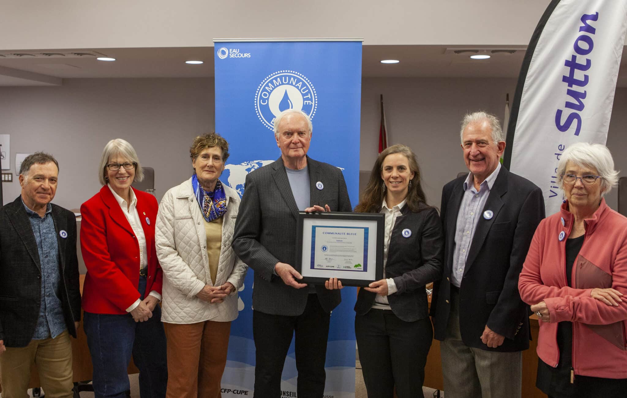 Les membres du conseil reçoivent la certification Communauté Bleue de la part de la directrice d’Eau Secours (de gauche à droite : Marc-André Blain, Lynda Graham, Marie-José Auclair, Robert Benoît, Rébecca Pétrin, Alan Pavilanis et Thérèse Leclerc).